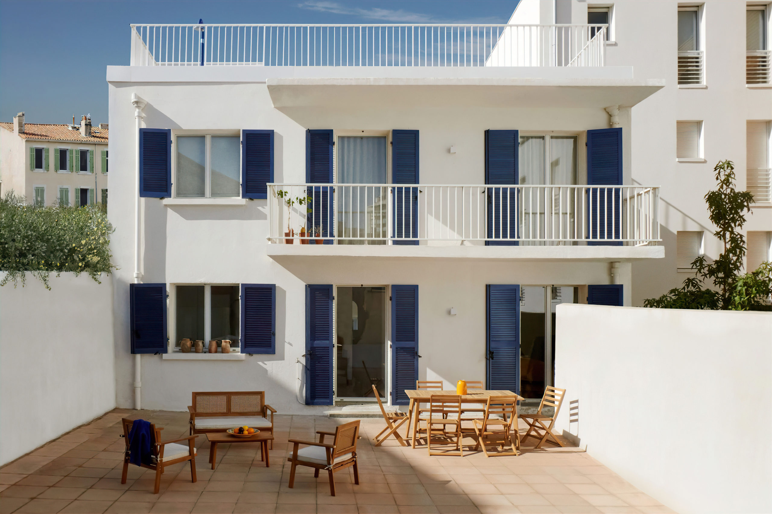 Petit immeuble et sa terrasse - esprit maison blanche avec des volets bleus. Architecture - Façades avec menuiseries extérieurs en aluminium blanc