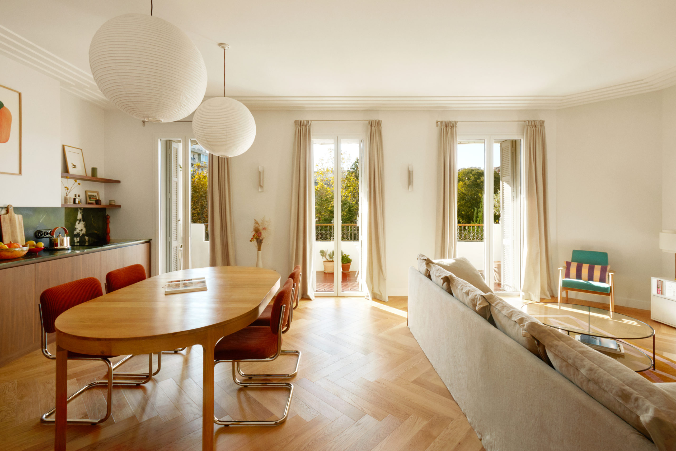 Pièce de vie cuisine et salon donnant sur un jardin arboré - parquet chevron