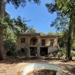 Maison isolée dans un écrin de verdure, nécessitant rénovation.