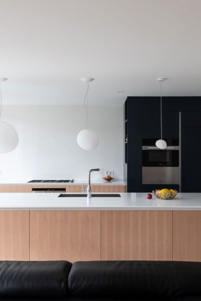 Cuisine moderne et lumineuse avec un îlot central en bois clair et noir.