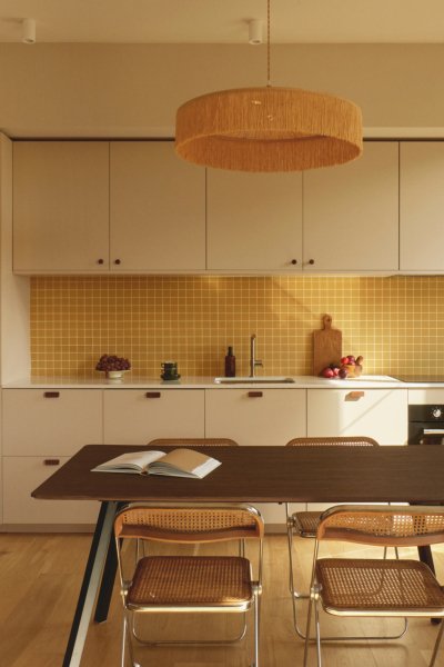 Cuisine moderne et lumineuse avec des armoires blanches et un backsplash jaune vif.
