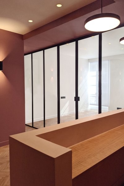 Une entrée lumineuse avec une paroi vitrée élégante et un meuble en bois chaleureux.